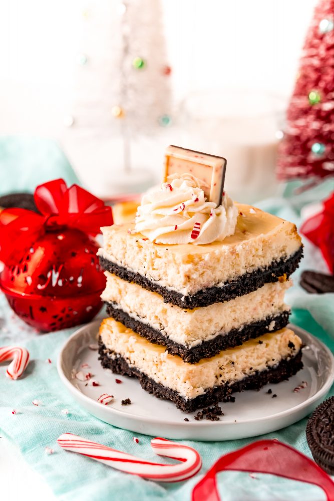 layers of cheesecake with chocolate in the middle and cream and peppermint chocolate on the top