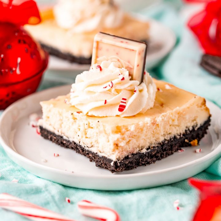 Peppermint Cheesecake Bars topped with whipped cream and candy canes.