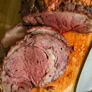 A sliced roast on a cutting board with a knife, prepared using the Grilled prime rib recipe.