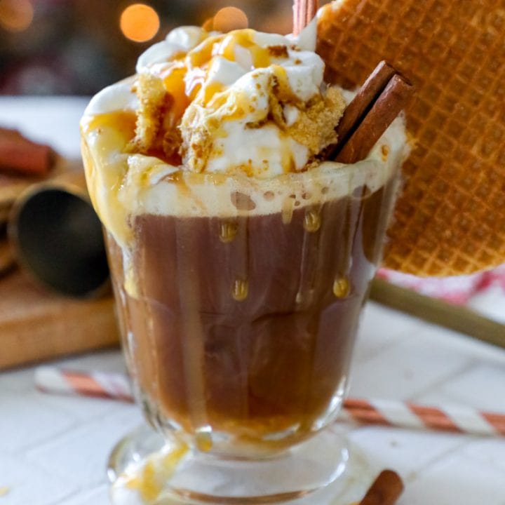 A coffee cocktail with whipped cream and cinnamon sticks, inspired by the flavors of stroopwafel and caramel.