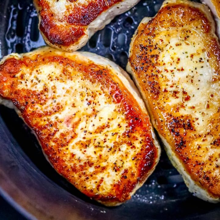 picture of pork chops in an air fryer basket
