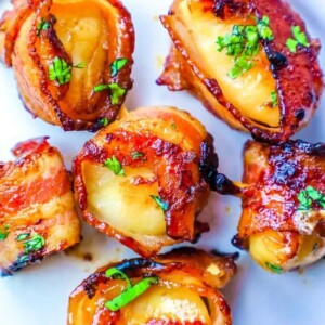 picture of bacon wrapped scallops with a brown sugar glaze topped with chopped parsley