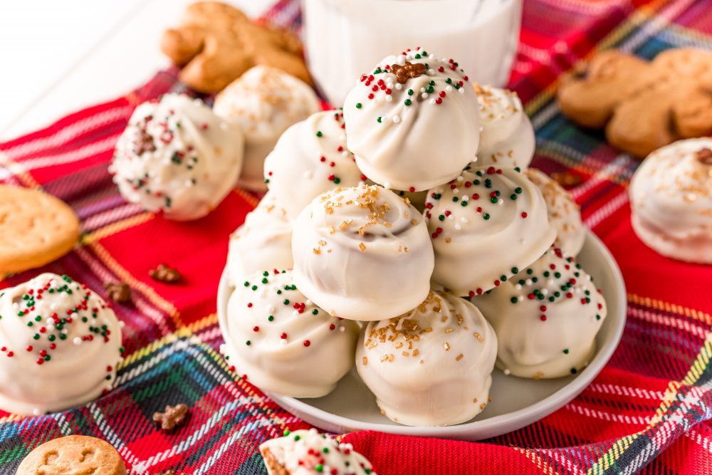 picture of gingerbread round cookie bites with sprinkles stacked on a plate. 