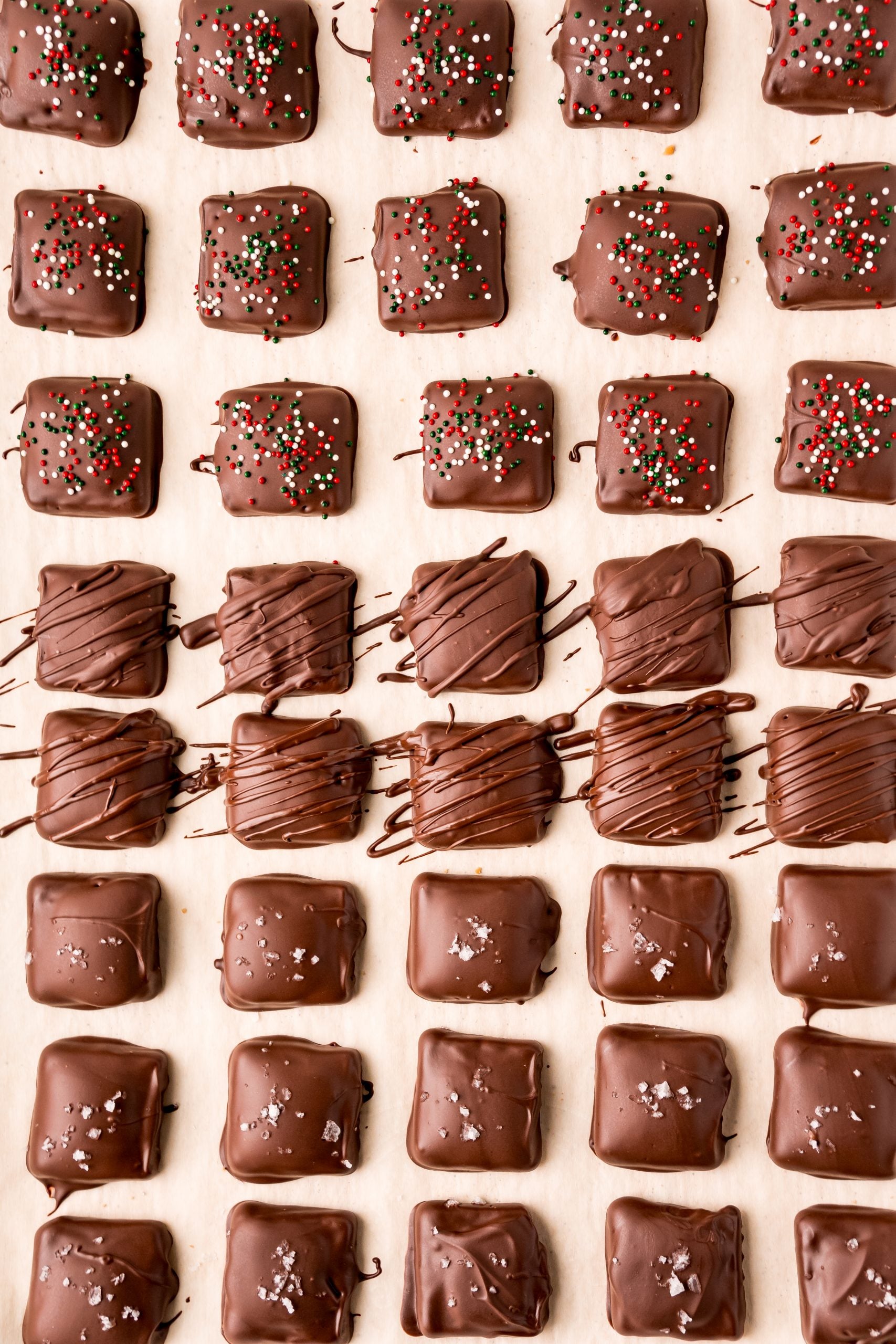 A row of chocolate covered candy canes and Shortcut Twix cookies on a table.