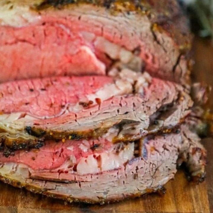 roasted prime rib sliced on a wood cutting board