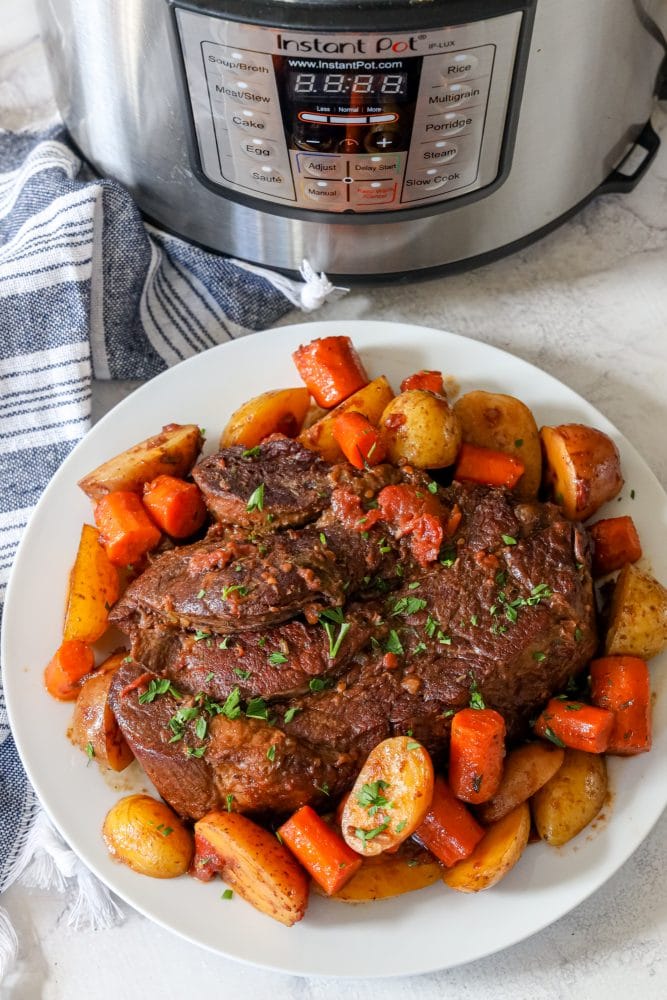 picture of pot roast and vegetables on a plate in front of an instant pot