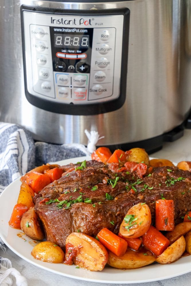 picture of pot roast and vegetables on a plate in front of an instant pot