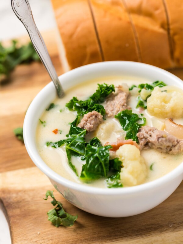 A keto zuppa toscana recipe with meat and kale displayed on a cutting board.