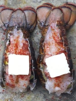 raw lobster tail with paprika and butter on top