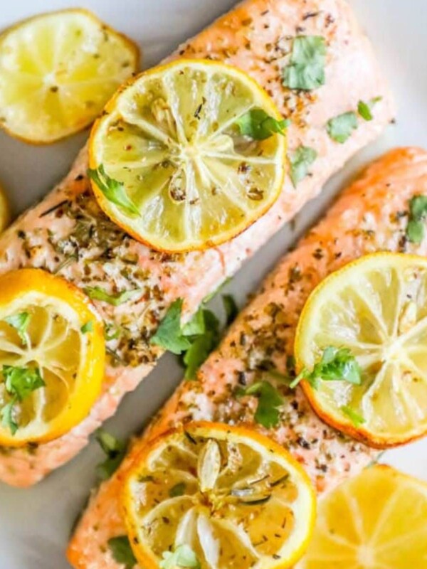 salmon filets on a white plate with lemon slices