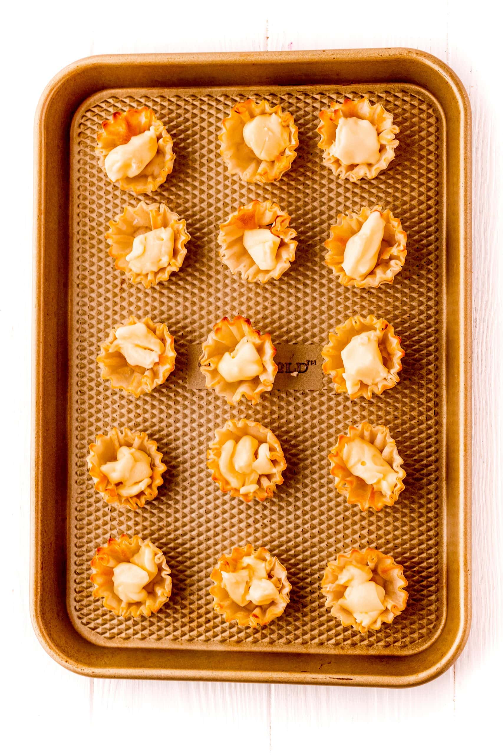 A diverse tray of small appetizers, including the delightful bacon-wrapped raspberry cheese bites, perfect for a party.