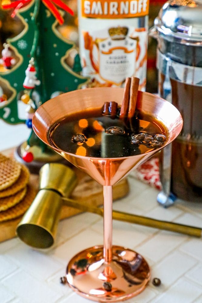 brass martini glass with coffee beans and cinnamon sticks in it