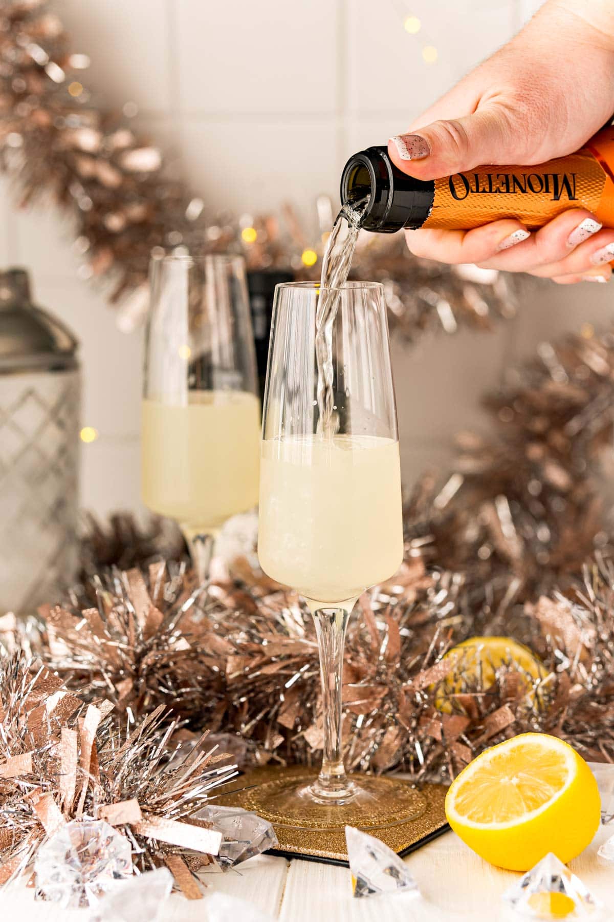 A person mixing gin and champagne to create an Easy Champagne Gin Fizz Cocktail.