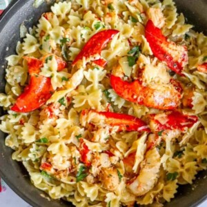 bowtie pasta in a pan with herbs, cheese, and lobster meat