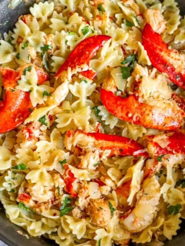 bowtie pasta in a pan with herbs, cheese, and lobster meat