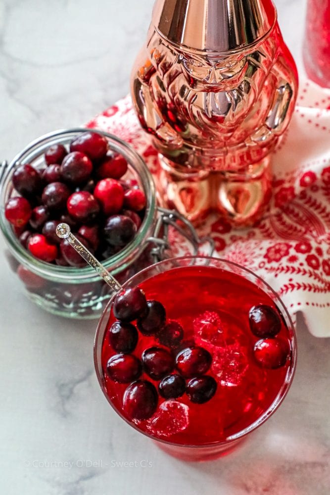 glass of cranberry juice with ice, and cranberries in it