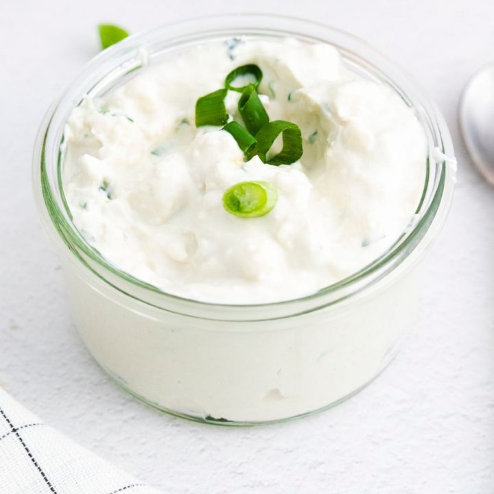 A bowl of sour cream with chives, transformed into a tangy and delicious blue cheese dip recipe.
