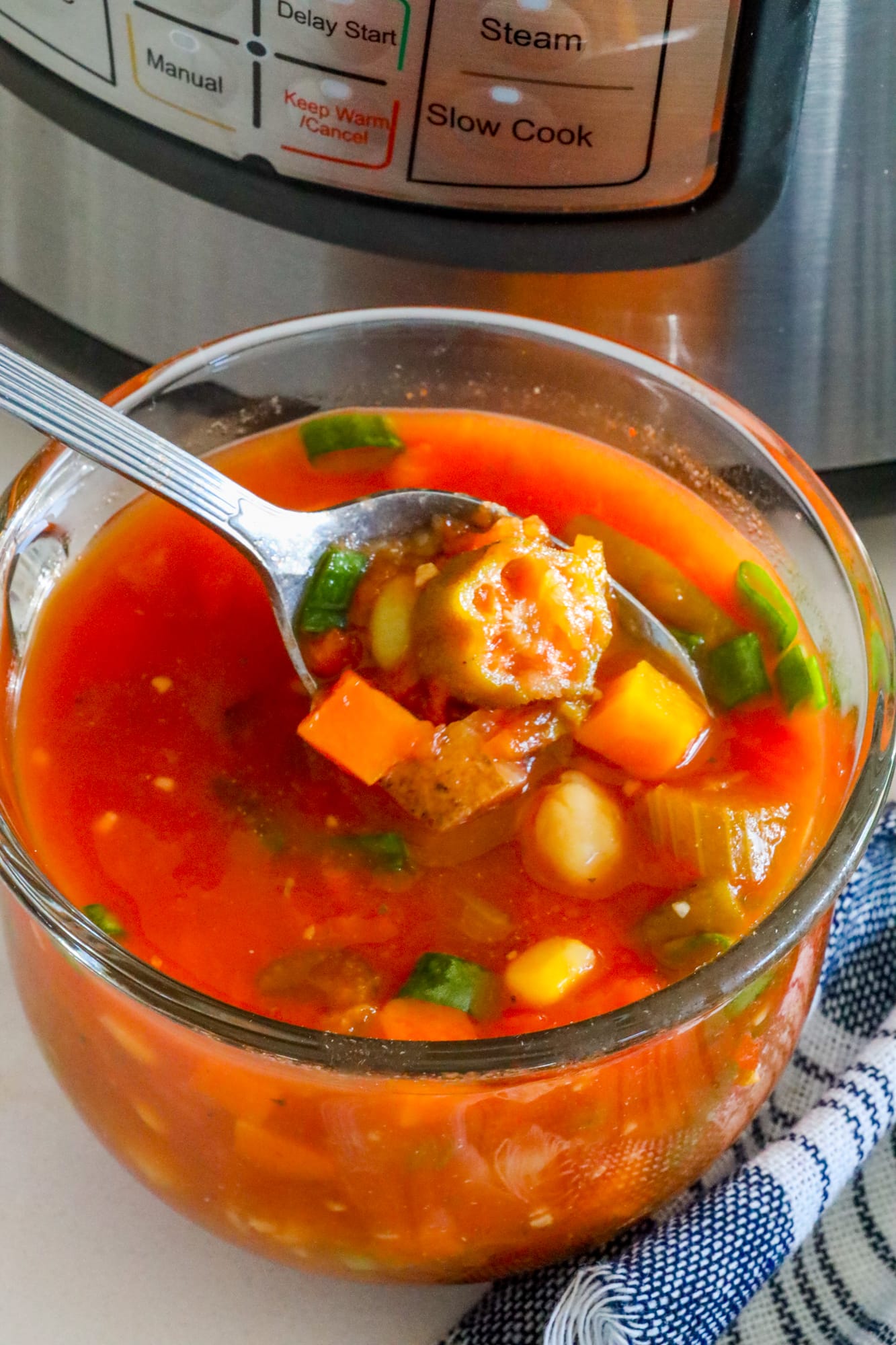 An easy instant pot vegan vegetable soup recipe displayed in front of an instant pot.
