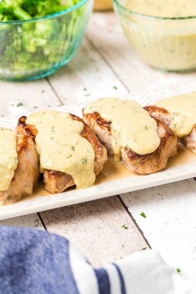 browned pork chops with white dijon sauce on it