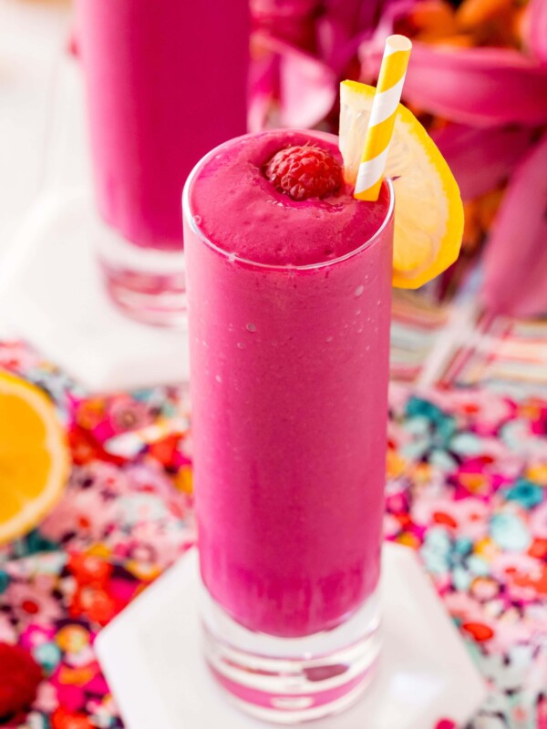Two glasses of raspberry beet smoothie with a slice of lemon.