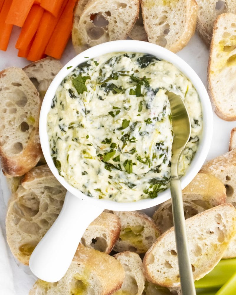spinach dip in the center with carrots and bread around it