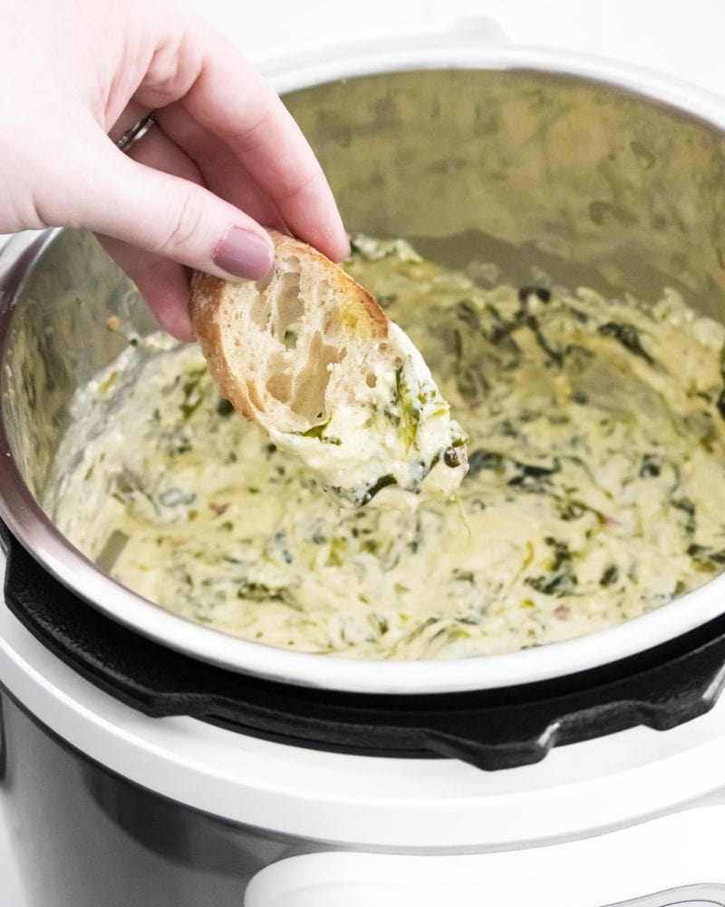 creamy dip with bread dipped into it