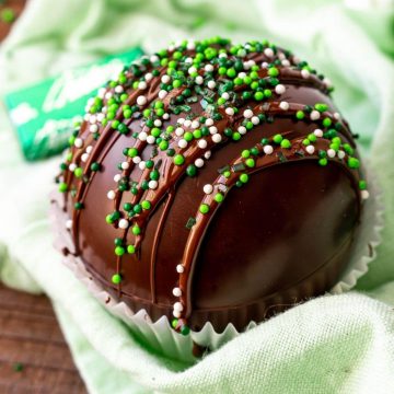 mint chocolate bombs smothered in a cupcake holder with green sprinkles.