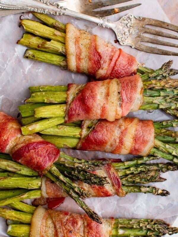 Bacon-wrapped asparagus baked on a sheet.