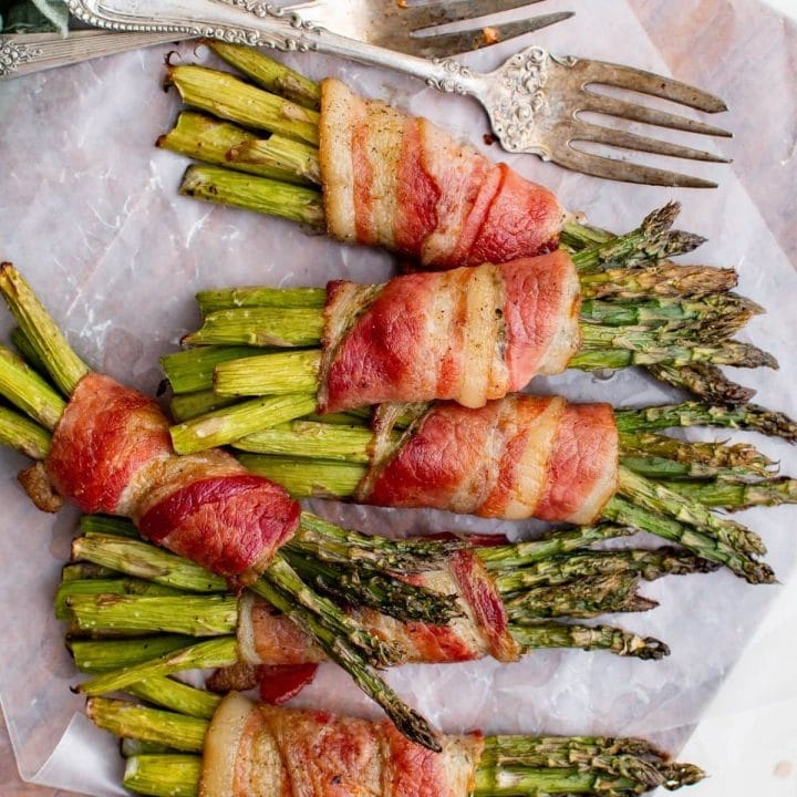 Bacon-wrapped asparagus baked on a sheet.