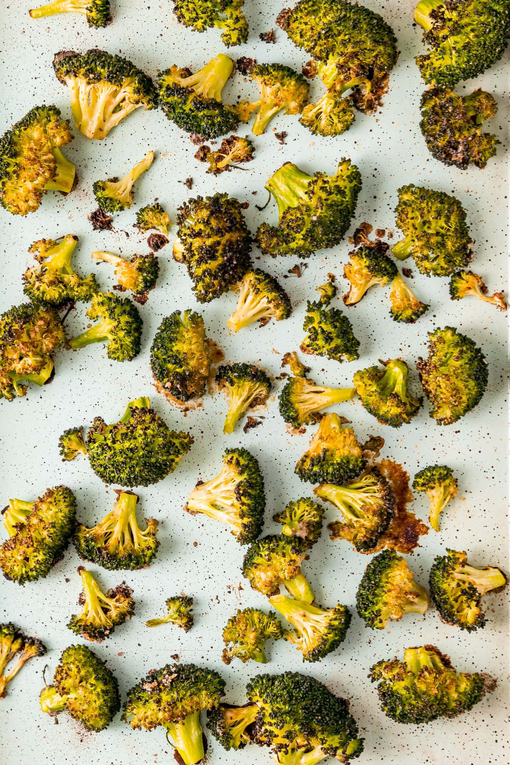 crispy cooked broccoli on a sheet pan lined with parchment paper