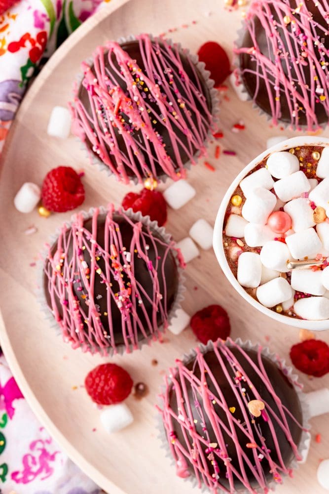 several chocolate balls with pink frosting and sprinkles on it