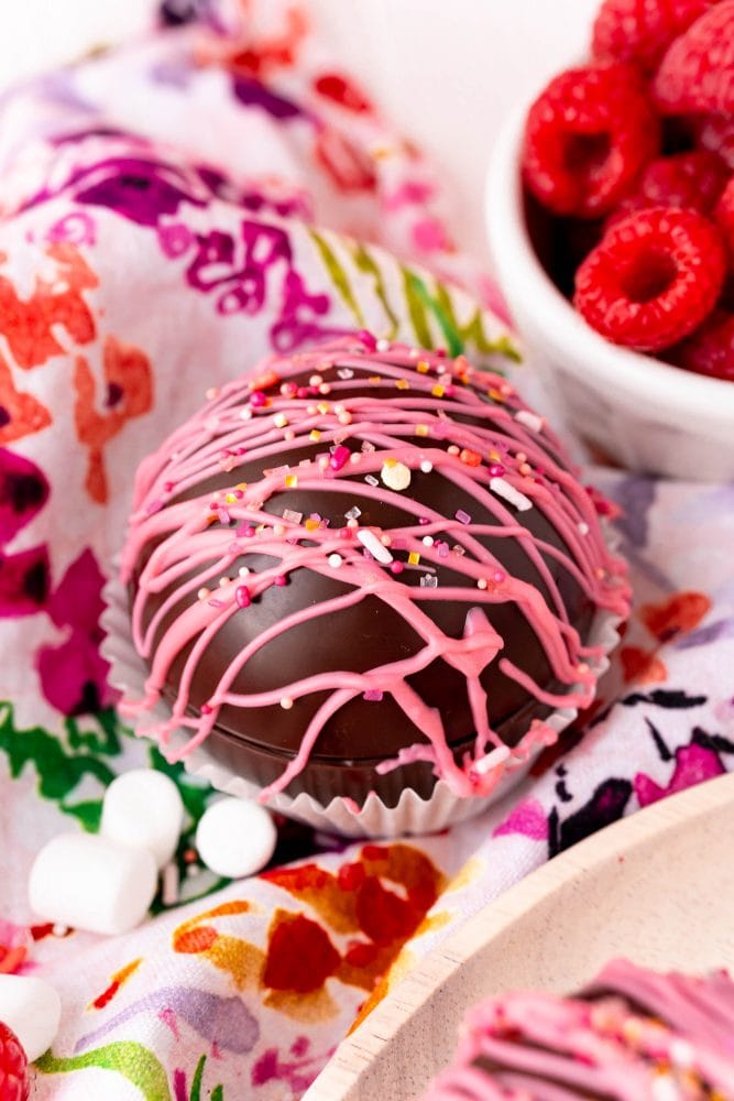 chocolate ball with pink frosting and sprinkles on it