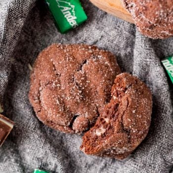 A double chocolate mint cookie with a bite taken out of it.