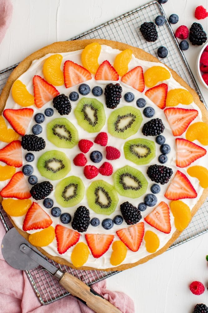 fruit cookie with cream and fruit arranged on top of the cream