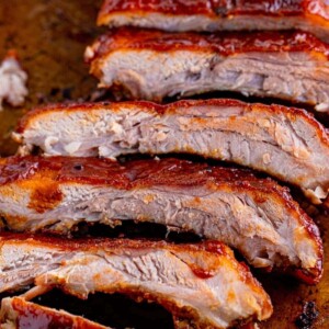 picture of sliced grilled ribs covered in bbq sauce on a baking sheet