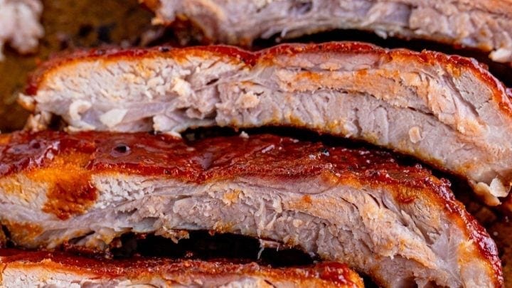 picture of sliced grilled ribs covered in bbq sauce on a baking sheet