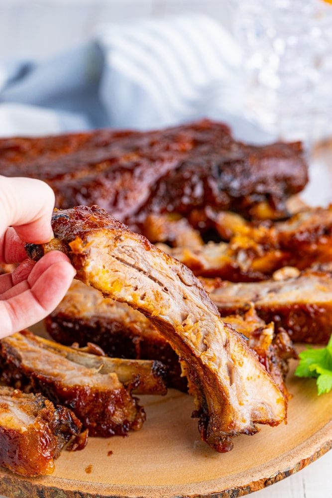 picture of ribs slathered in sauce on a wood platter