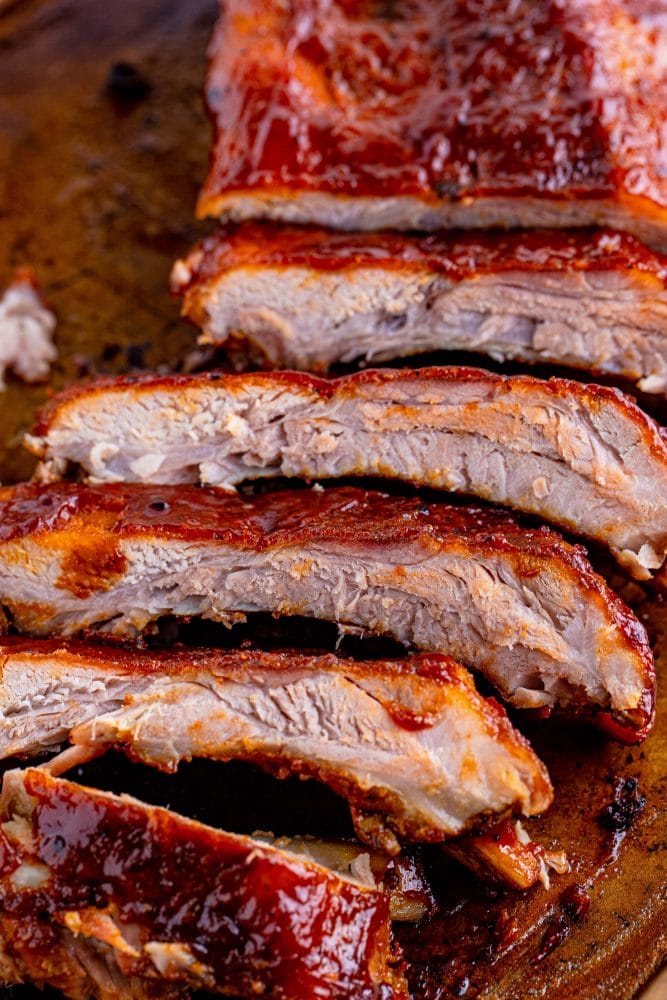 picture of ribs slathered in sauce on a wood platter