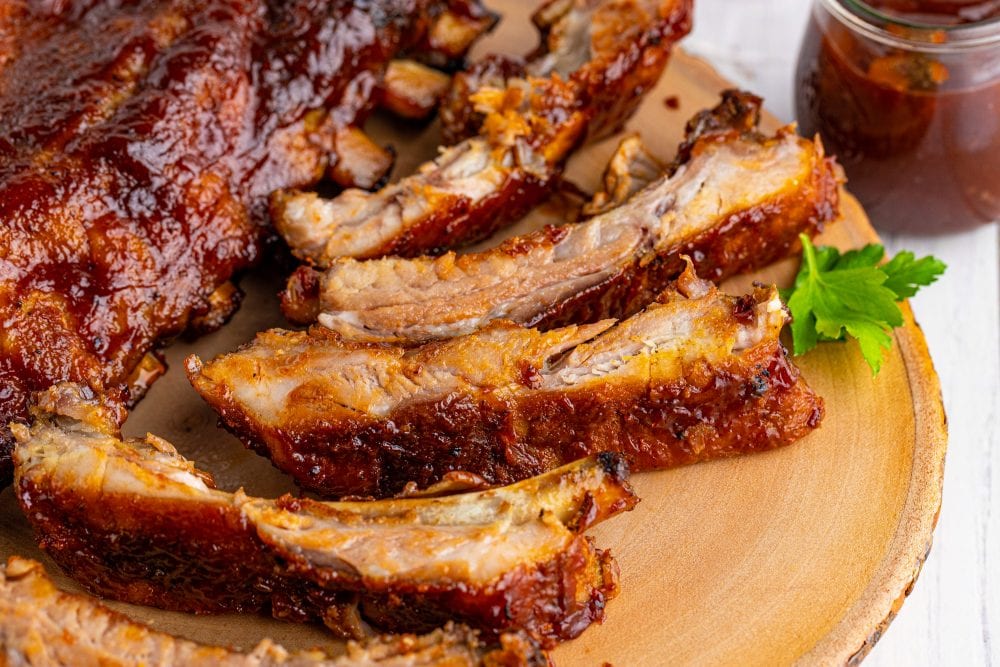 picture of ribs slathered in sauce on a wood platter