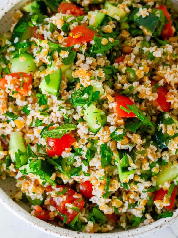 The Best Easy Tabbouleh Recipe featuring a bowl of couscous salad with tomatoes and cucumbers.