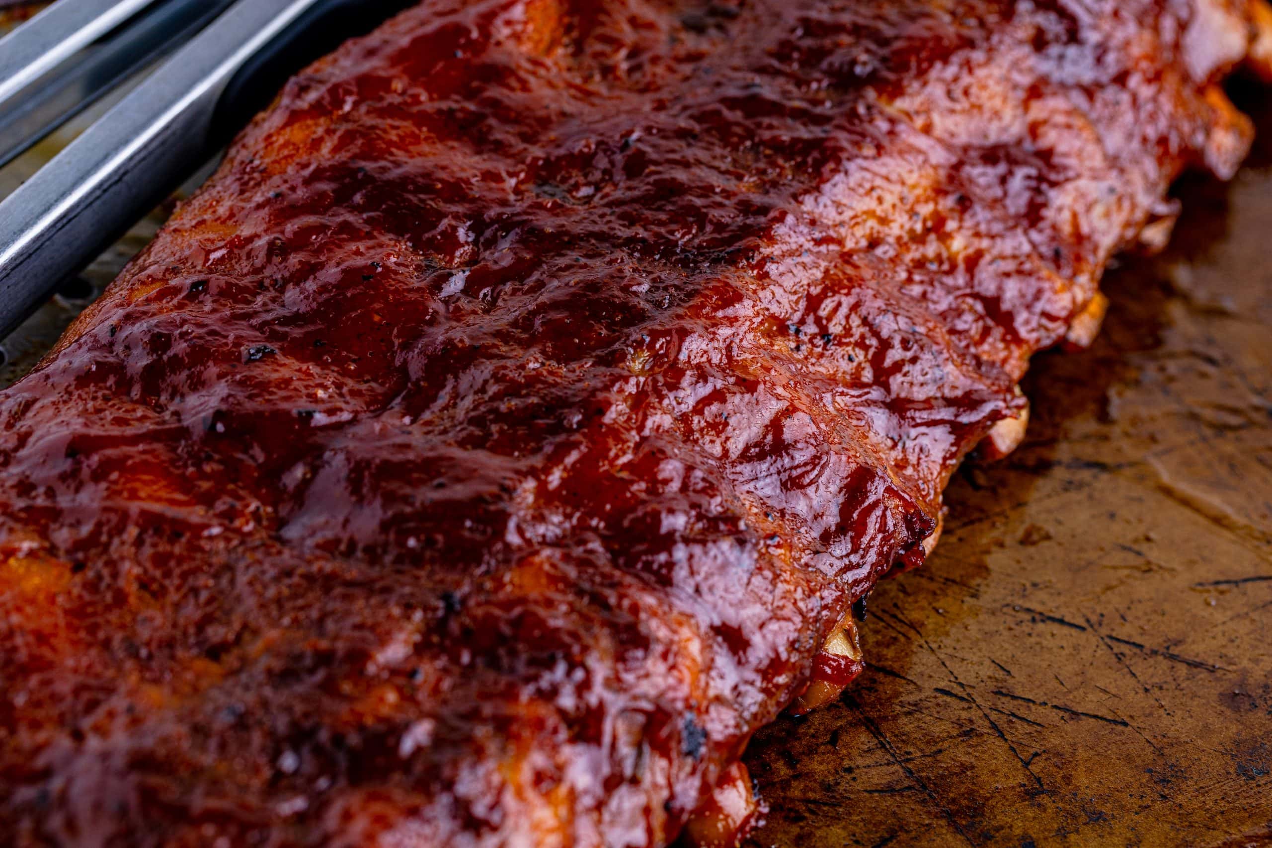 picture of ribs slathered in bbq sauce on a baking sheet