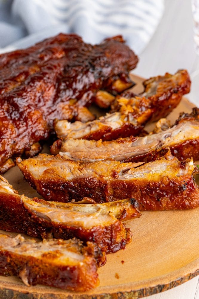 picture of ribs slathered in sauce on a wood platter