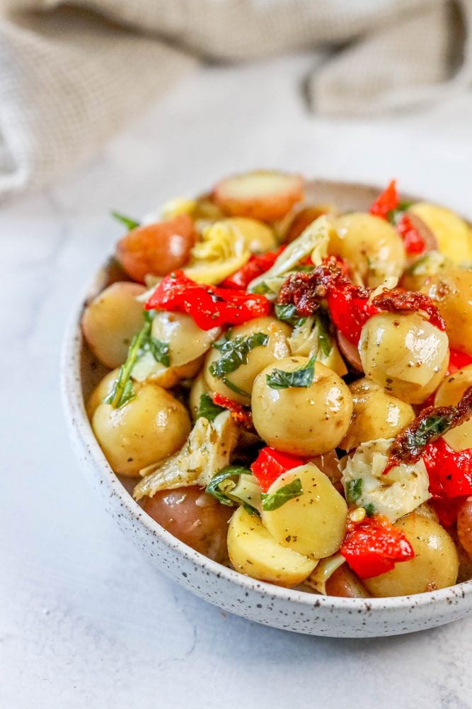 picture of potatoes, basil, artichokes, sun dried tomatoes, and roasted red peppers in a bowl 