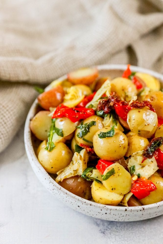 picture of potatoes, basil, artichokes, sun dried tomatoes, and roasted red peppers in a bowl 