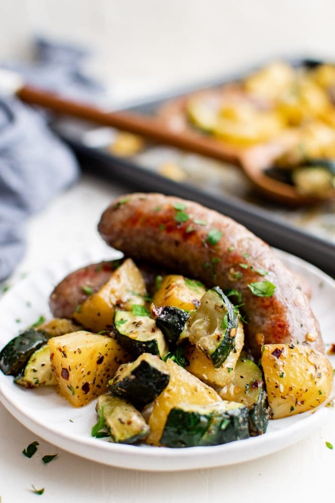 picture of sausage potatoes and zucchini on a white plate