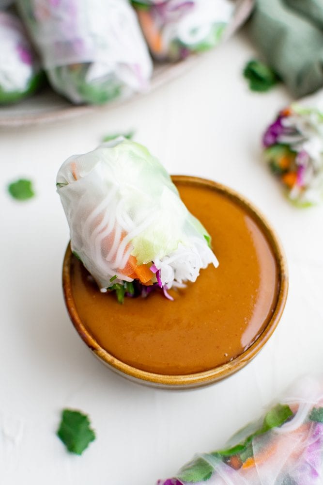 picture of spring roll dipping into peanut sauce
