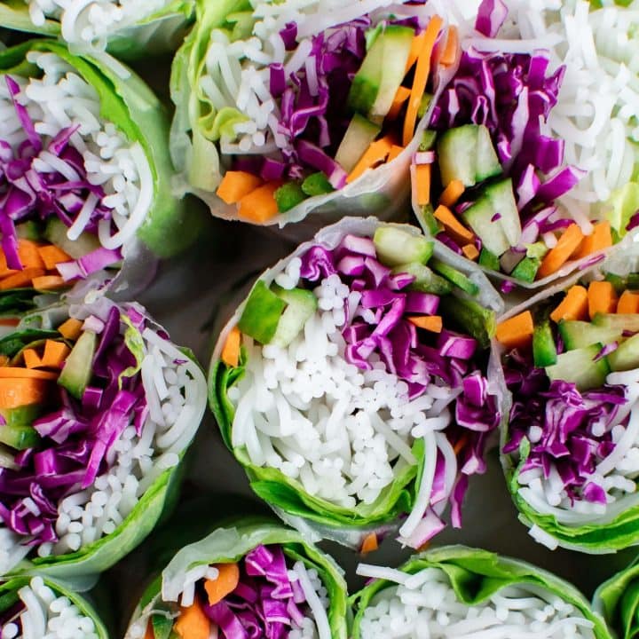 Vegan Vietnamese spring rolls with shredded carrots and cabbage, served with peanut sauce.