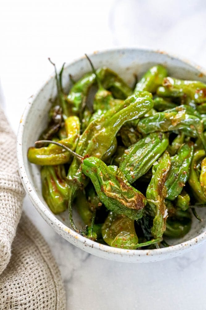 shishito peppers in a bowl on a table