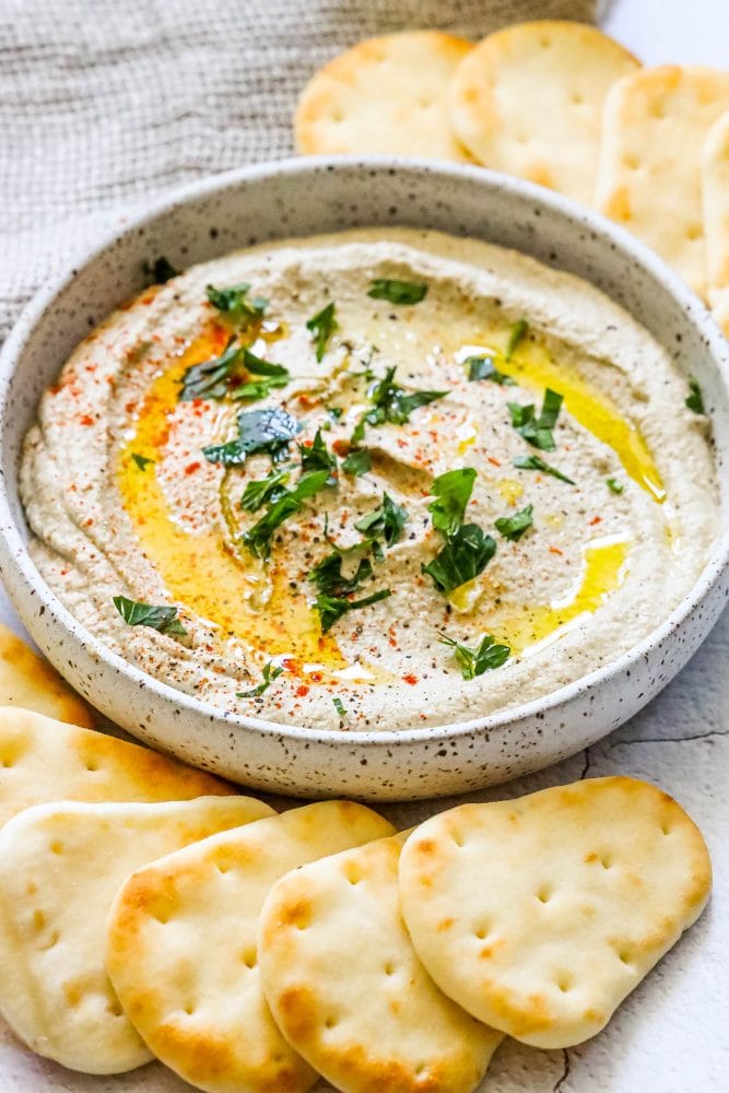 baba ganoush on a table surrounded by pita
