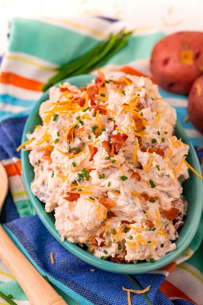 ranch potato salad in a blue bowl on a colorful towel